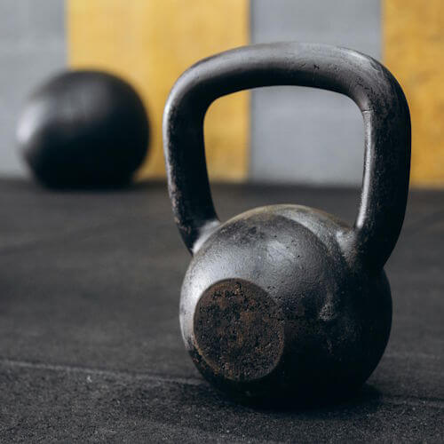Kettlebell op mat voor flexibele online coaching training. Thuis workouts PT Breda Dordrecht